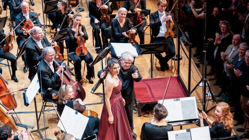 Claus Peter Flor and Katerina Bradić inviting the post horn soloist, Bob Koerthuis, onto the stage to take the applause