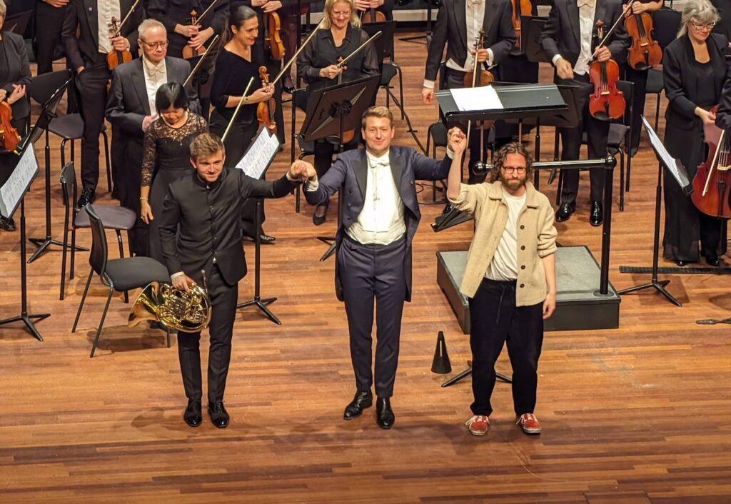 Gavin Higgins joins Ben Goldscheider and Duncan Ward on stage in March 2024 after the European premiere of his horn Concerto with Phil Zuid 
